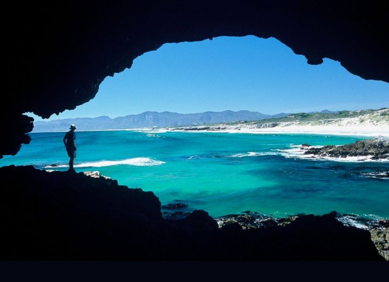 Hiker Looking Out On The Ocean From A Landbased Cave Image On Contact Us Page